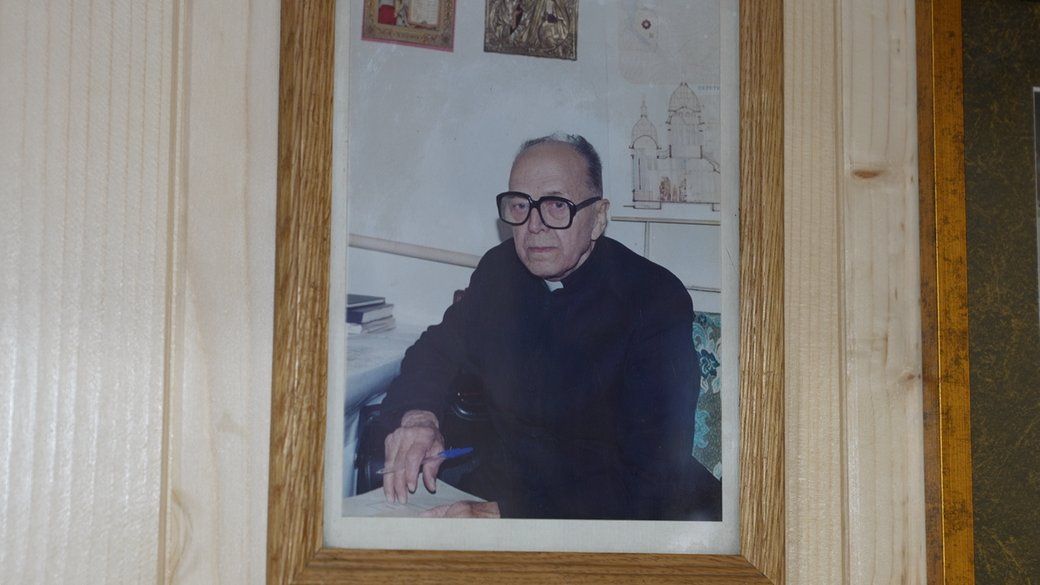 Фотографія отця Івана, який сидить за робочим столом, Івано-Франківськ. 