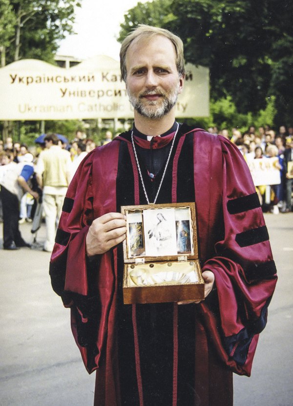 Борис Ґудзяк перед місцем майбутнього кампусу УКУ, територію якого у цей день посвятив Папа Іван Павло ІІ. В руках переносний престол з часів підпілля УГКЦ, який був вручений Папі як символічний дарунок, 26 червня 2001 року